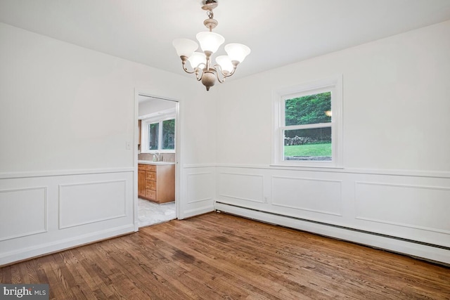 8205 Robin Hood Ct, Towson, MD 21204 - spare room featuring a chandelier, a decorative wall, a baseboard heating unit, wood finished floors, and a wainscoted wall