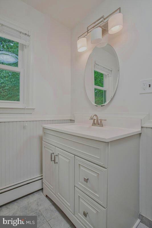 8205 Robin Hood Ct, Towson, MD 21204 - bathroom featuring baseboard heating, vanity, and wainscoting