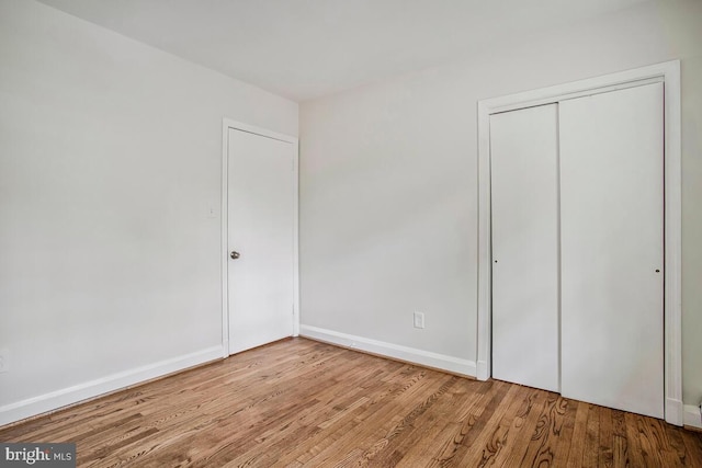 8205 Robin Hood Ct, Towson, MD 21204 - unfurnished bedroom with wood finished floors, a closet, and baseboards