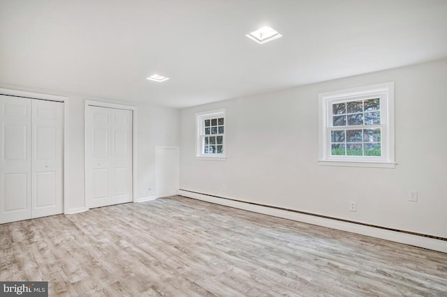 8205 Robin Hood Ct, Towson, MD 21204 - unfurnished bedroom with baseboard heating, two closets, wood finished floors, and baseboards