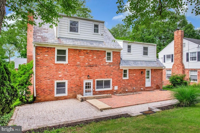 8205 Robin Hood Ct, Towson, MD 21204 - rear view of property featuring a high end roof, brick siding, a patio area, and a chimney