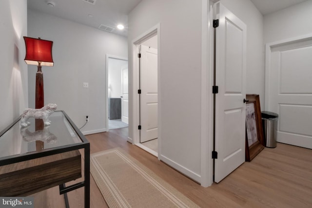 hall featuring light wood finished floors and baseboards