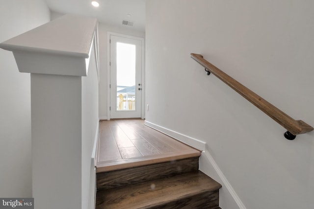 staircase with visible vents, baseboards, recessed lighting, and wood finished floors