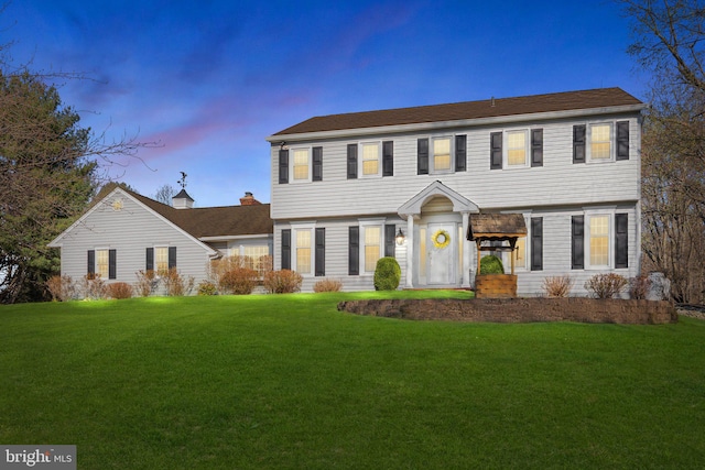 colonial inspired home with a yard