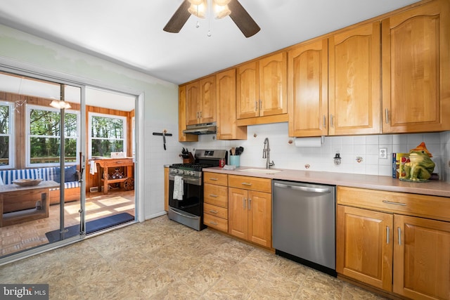 kitchen with ceiling fan, tasteful backsplash, a sink, under cabinet range hood, and stainless steel appliances