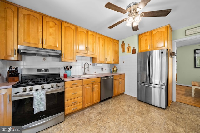 kitchen featuring ceiling fan, appliances with stainless steel finishes, light countertops, a sink, and under cabinet range hood