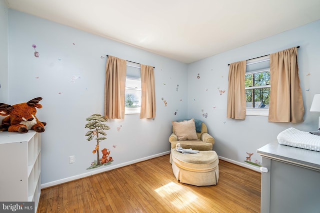 living area featuring baseboards and hardwood / wood-style flooring
