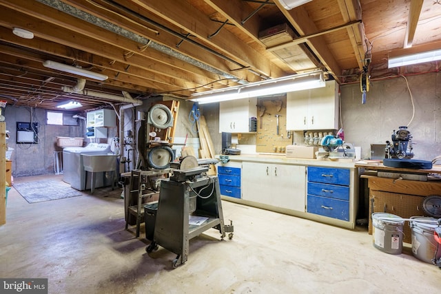 basement featuring a sink, a workshop area, and independent washer and dryer