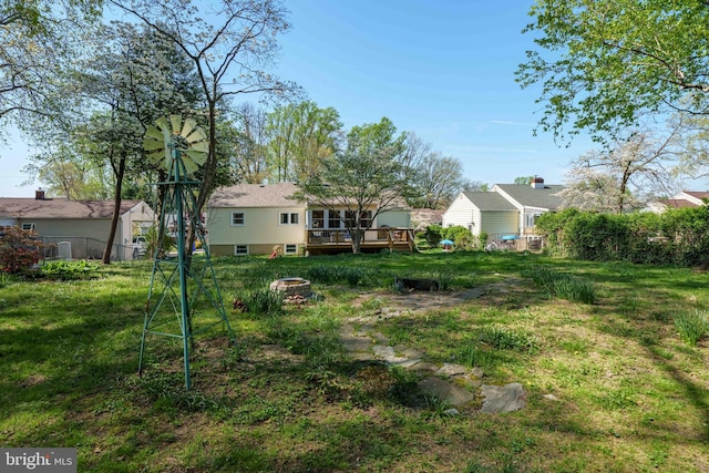view of yard with a fire pit, a wooden deck, and fence