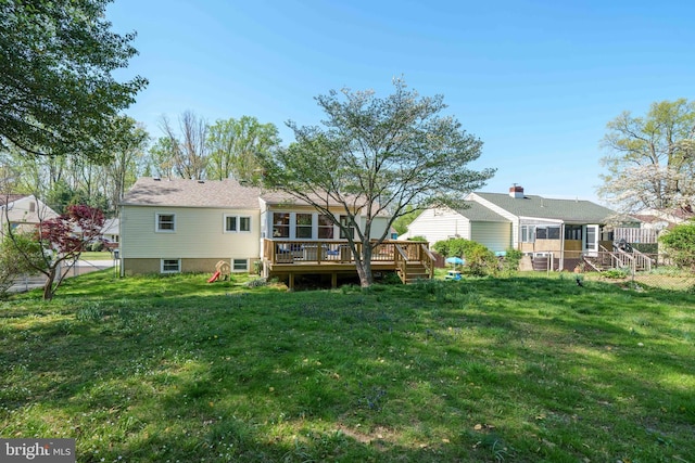 back of house with a sunroom, a yard, and a deck