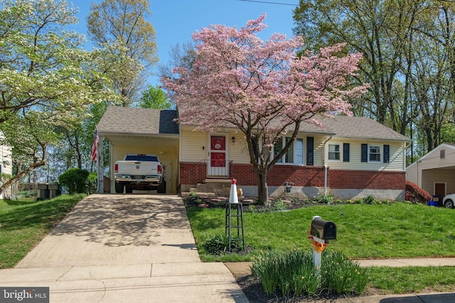 view of front facade featuring brick siding, driveway, a front yard, and an attached carport