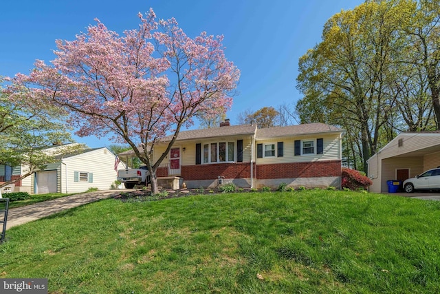 ranch-style home with brick siding, a chimney, a front yard, and a carport