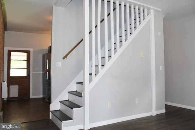 stairway with wood finished floors and baseboards