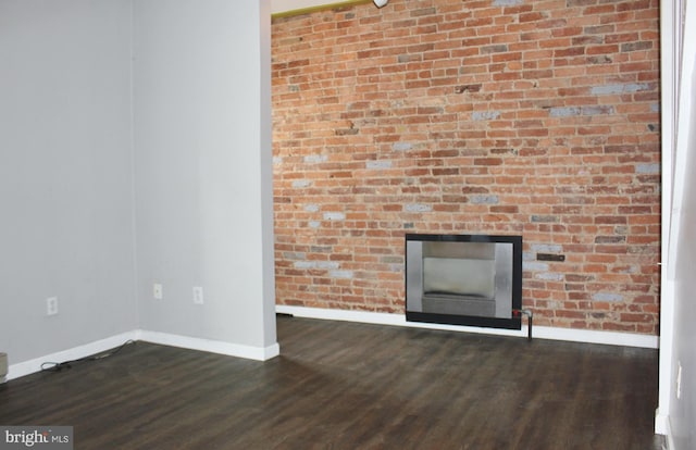 unfurnished living room featuring baseboards, wood finished floors, and a fireplace