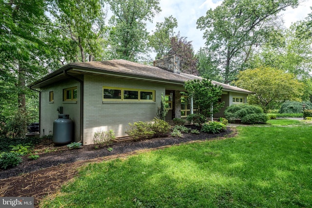 142 Woodside Rd, Lancaster, PA 17601 - view of front of home featuring brick siding, a front lawn, and a chimney