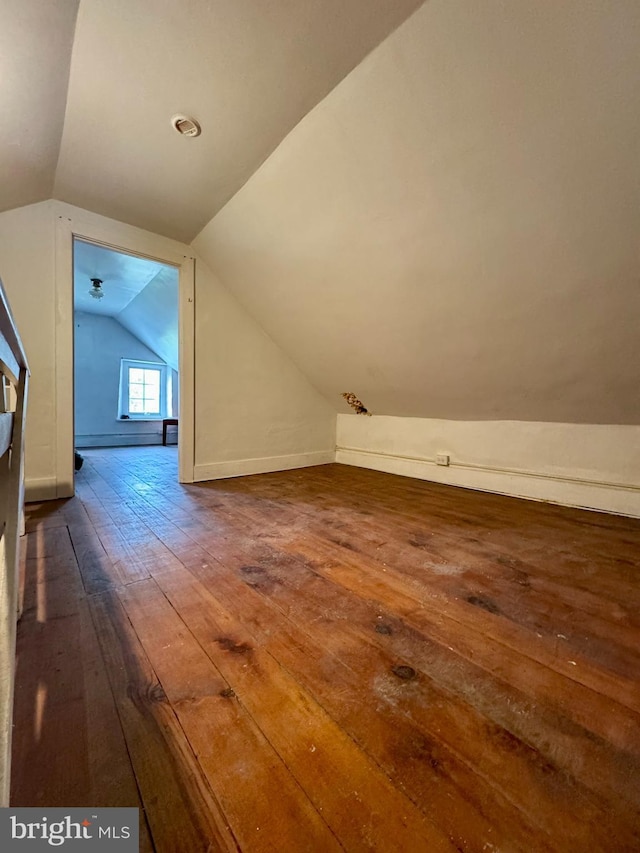 additional living space featuring wood-type flooring and lofted ceiling