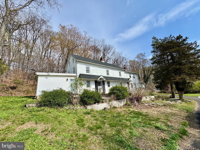 view of front of house with a chimney and stucco siding