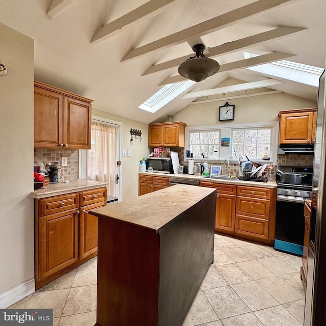 kitchen with a sink, decorative backsplash, ceiling fan, and stainless steel appliances