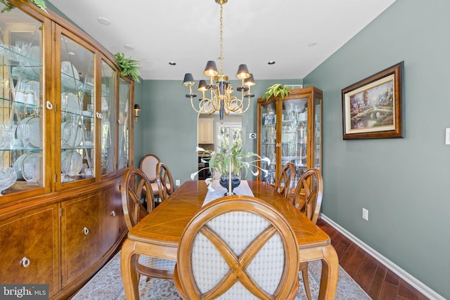 dining area featuring baseboards, wood finished floors, and a chandelier