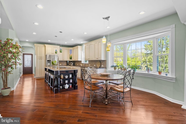 dining space with arched walkways, baseboards, dark wood finished floors, and recessed lighting