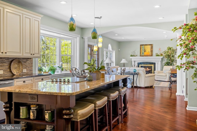 kitchen featuring a healthy amount of sunlight, cream cabinets, dark wood-style floors, and black electric cooktop