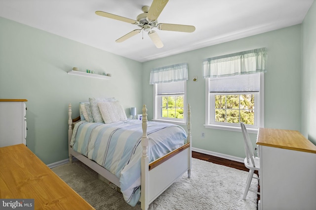 bedroom with a ceiling fan, baseboards, and wood finished floors