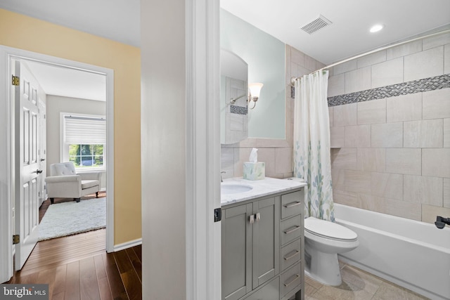 bathroom featuring shower / bath combination with curtain, visible vents, vanity, toilet, and recessed lighting