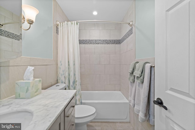 full bathroom featuring toilet, tile walls, shower / bath combo, and vanity