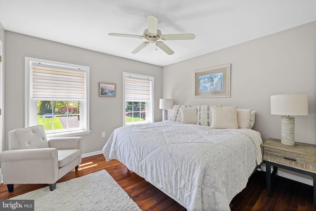 bedroom with a ceiling fan, baseboards, and dark wood finished floors