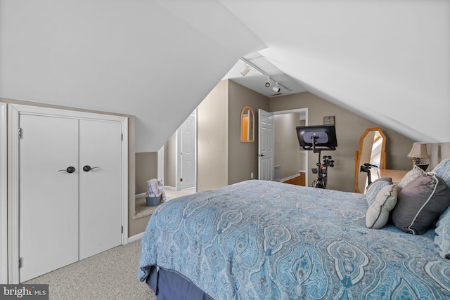 bedroom with baseboards, carpet, lofted ceiling, and track lighting
