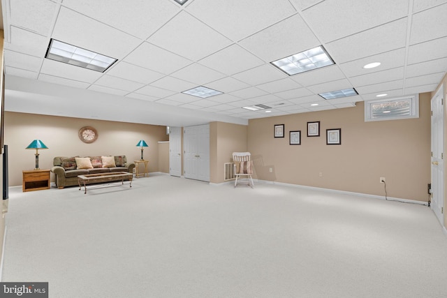 finished below grade area featuring carpet floors, baseboards, and a drop ceiling