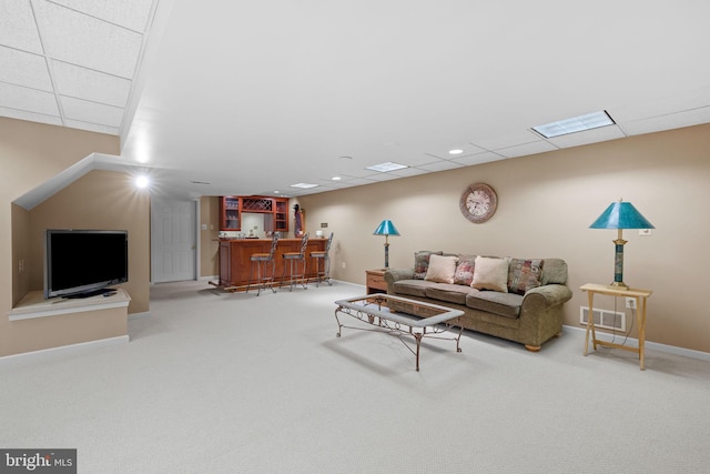 living room with visible vents, carpet, baseboards, and bar area