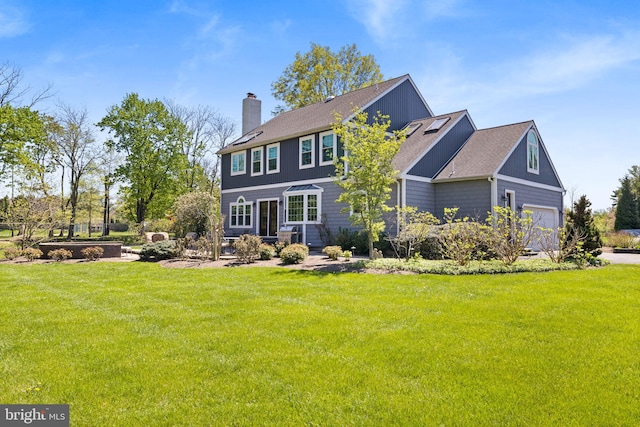 back of property with a lawn, a chimney, and roof with shingles