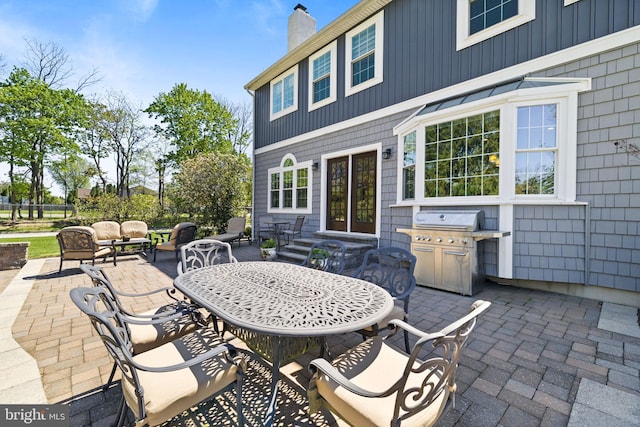 view of patio with area for grilling, outdoor dining space, an outdoor hangout area, and entry steps