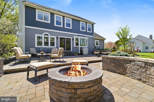 back of property featuring an outdoor fire pit, a patio area, and entry steps