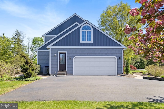 craftsman-style home with cooling unit and driveway