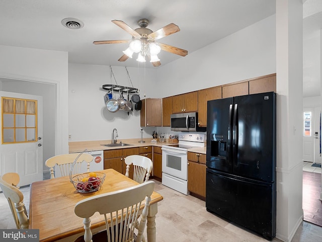 9 Honeysuckle Dr, Newark, DE 19702 - kitchen with white electric range oven, stainless steel microwave, black fridge with ice dispenser, a sink, and visible vents