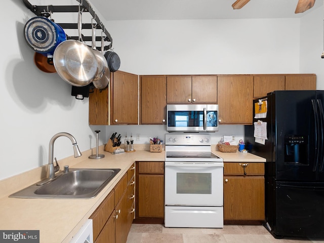 9 Honeysuckle Dr, Newark, DE 19702 - kitchen featuring stainless steel microwave, a sink, black refrigerator with ice dispenser, white range with electric cooktop, and brown cabinetry