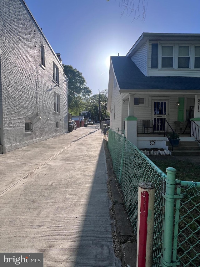 view of home's exterior with a porch and fence