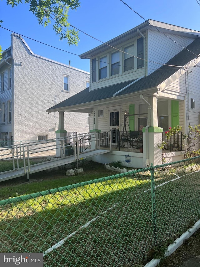 rear view of house with fence and covered porch