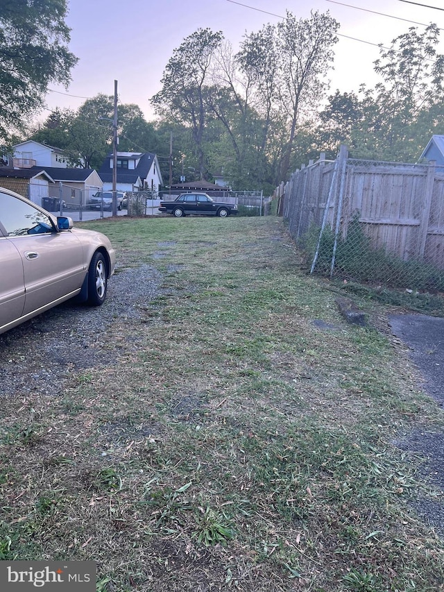yard at dusk featuring fence