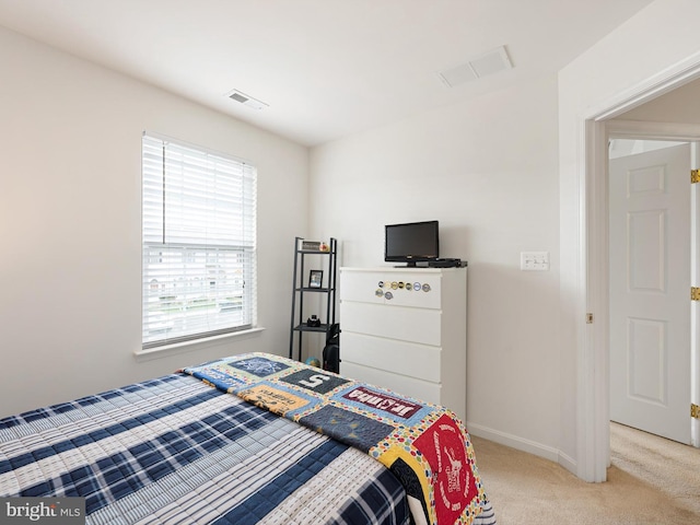 bedroom with baseboards, visible vents, and light colored carpet