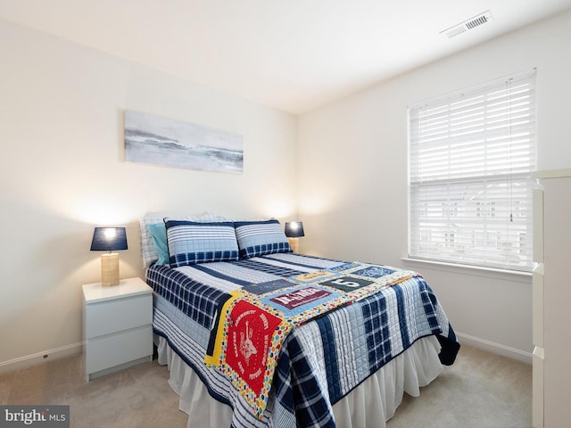 bedroom featuring visible vents, baseboards, and light carpet
