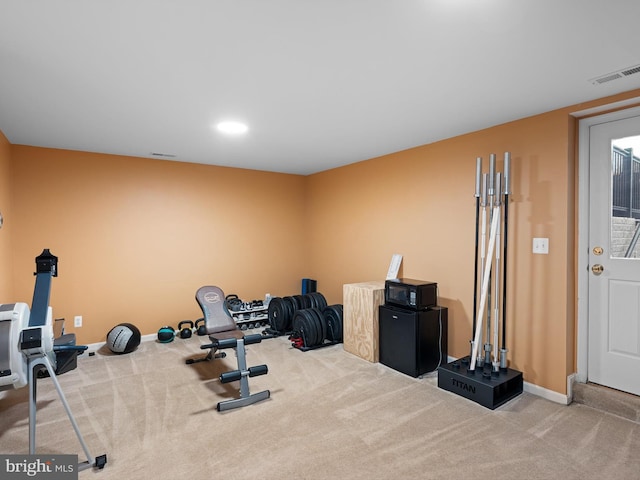 workout room with baseboards, visible vents, and carpet