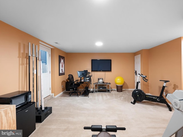 exercise room with baseboards and carpet