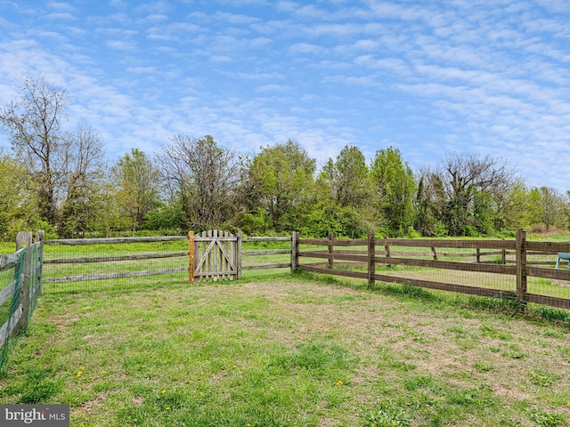 view of yard with a rural view and fence