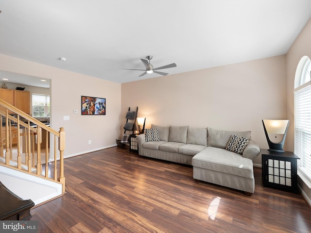 living area featuring baseboards, a ceiling fan, wood finished floors, and stairs
