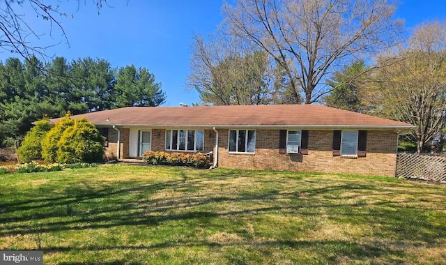 single story home with a front yard, brick siding, and fence