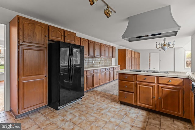 29 Foxcroft Dr, Princeton, NJ 08540 - kitchen with wall chimney range hood, freestanding refrigerator, stovetop with downdraft, brown cabinets, and decorative backsplash