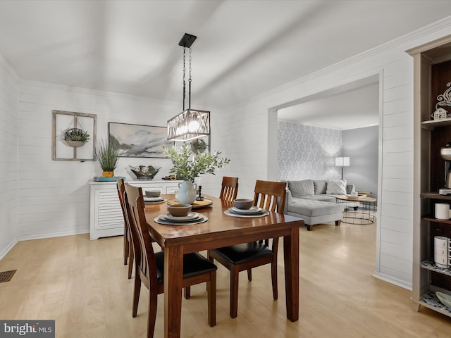 dining space with light wood-style flooring, a chandelier, and baseboards